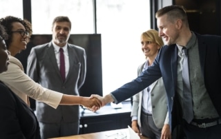 colleagues shaking hands after discussing the benefits of customer support outsourcing