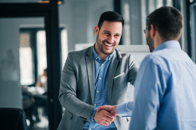 Portrait of cheerful young manager handshake with customer service outsourcing partner