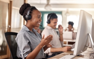 A call center agent cheerfully conducts an outbound call in a busy outgoing call center.