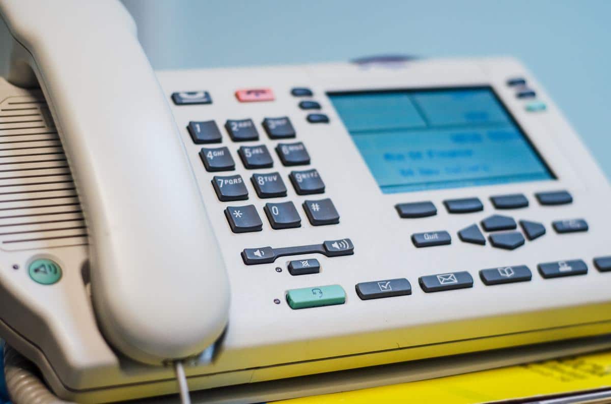 Close-up of a landline business phone with a caller ID screen, displaying the ANI number of the caller.