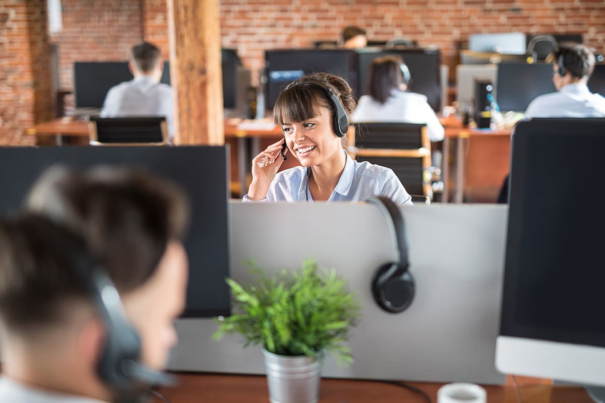 A call center agent performs a warm transfer and preps another agent for an incoming call.