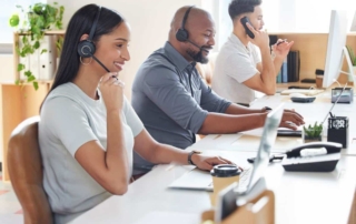 Call center agents cheerfully talking to customers over their phones.