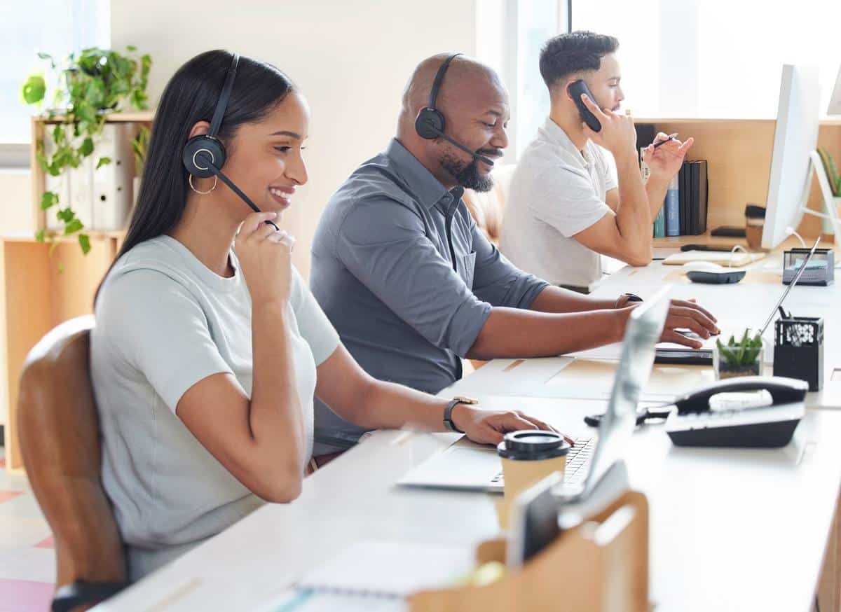 Call center agents cheerfully talking to customers over their phones.