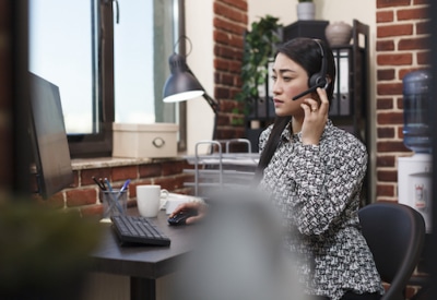 Female call center agents provide customer service through their telephone headsets.