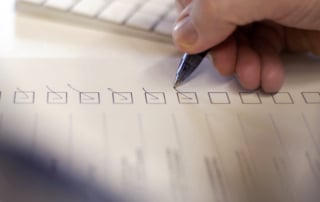 a person checking off items on a call center compliance checklist