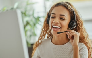 a call center agent happily talking on a headset as part of a customer care outsourcing team