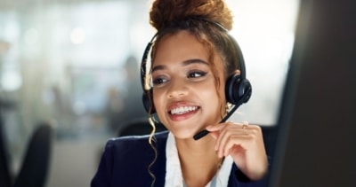 A call center agent provides cheerful customer service over the phone.