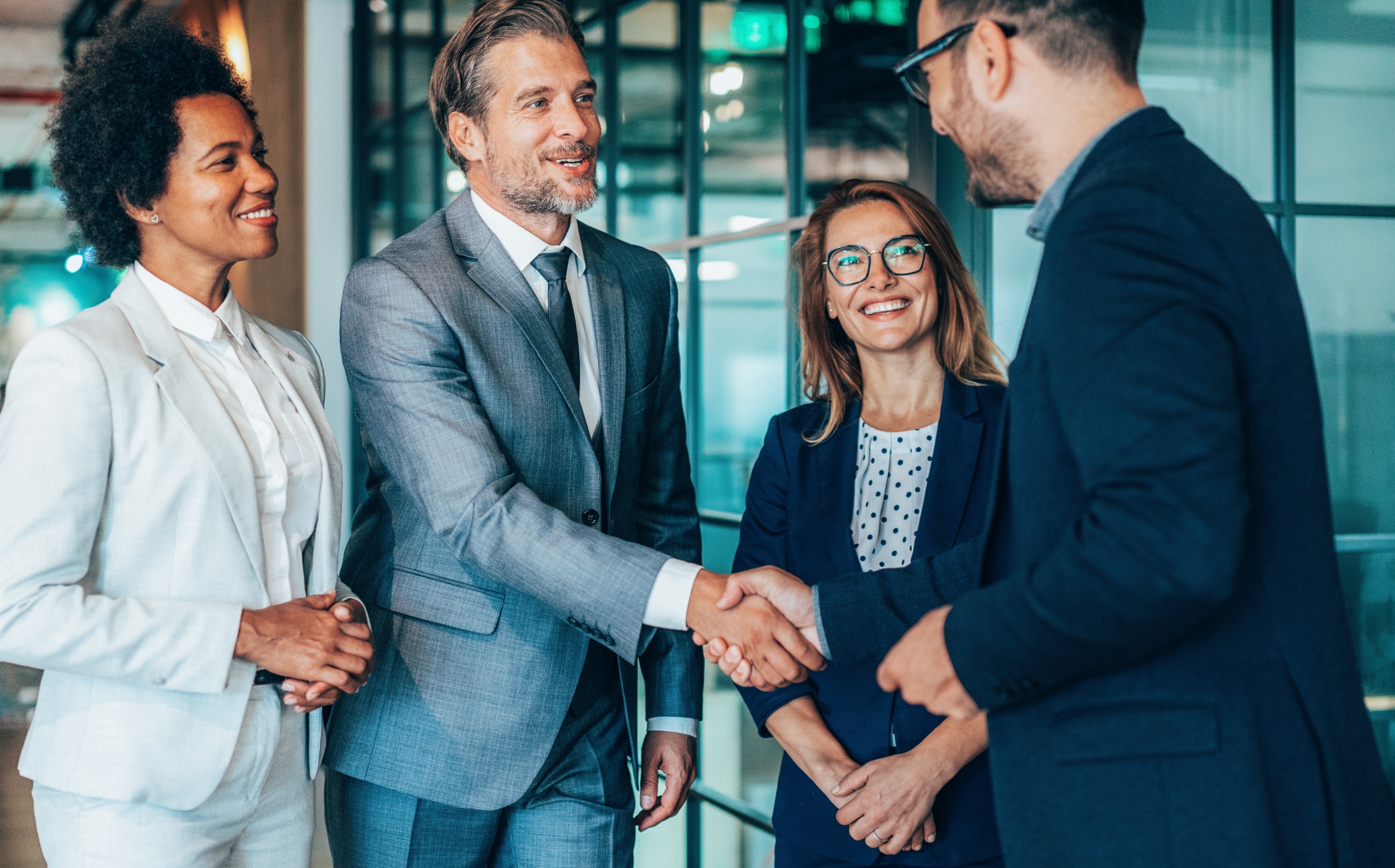 A business owner shakes hands with a representative of their new call center outsourcing partner.