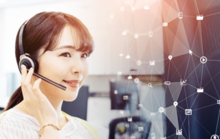 A contact center agent smiles while taking a call, supported by AI contact center tools, illustrated by a web of icons superimposed in front of her.