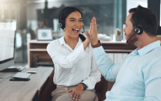 Two call center agents high-fiving each other