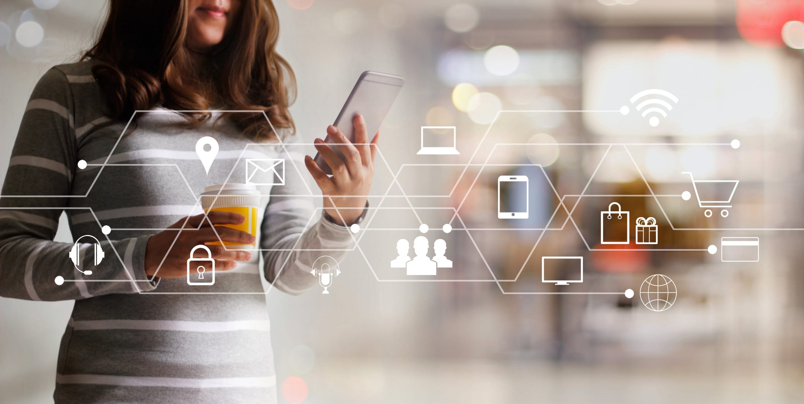 A woman looks at her smartphone, getting in touch with customer support through an omnichannel contact center, as represented by the superimposed diagram of communication channel icons.