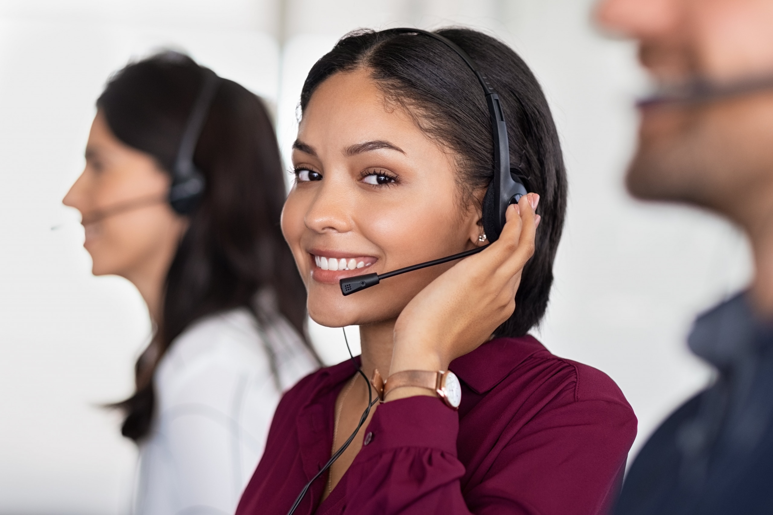 Smiling woman working in a call center as a telemarketing operator.