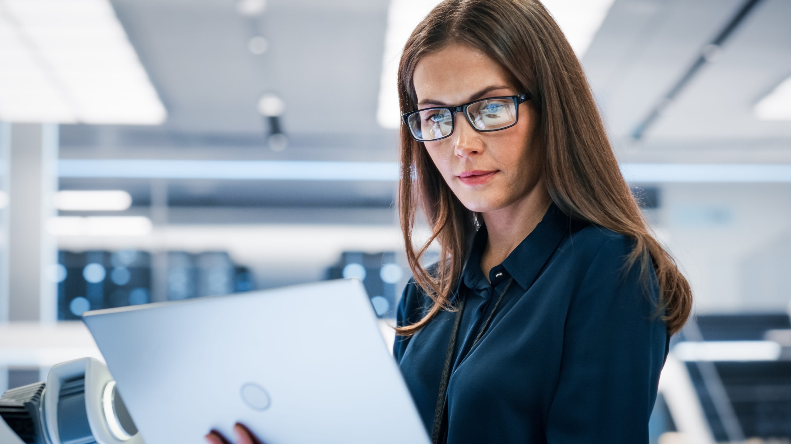 Close-up portrait of a young engineer using a laptop computer.