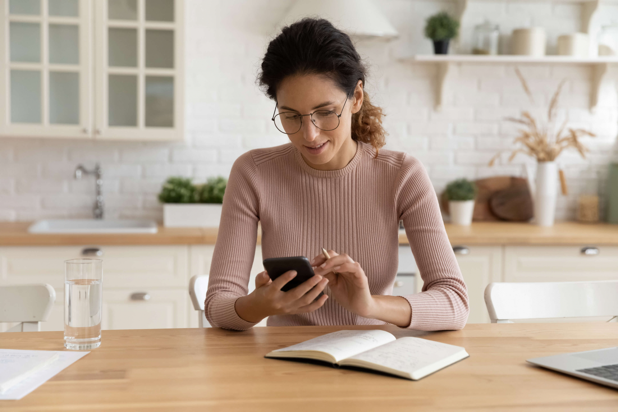Woman sitting at her table on her cell phone