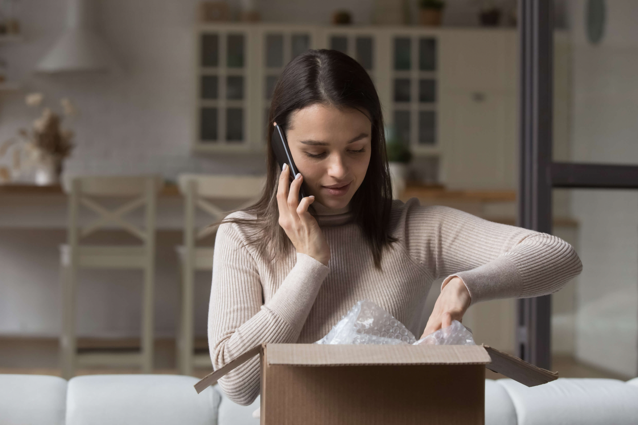 young woman on phone opening package
