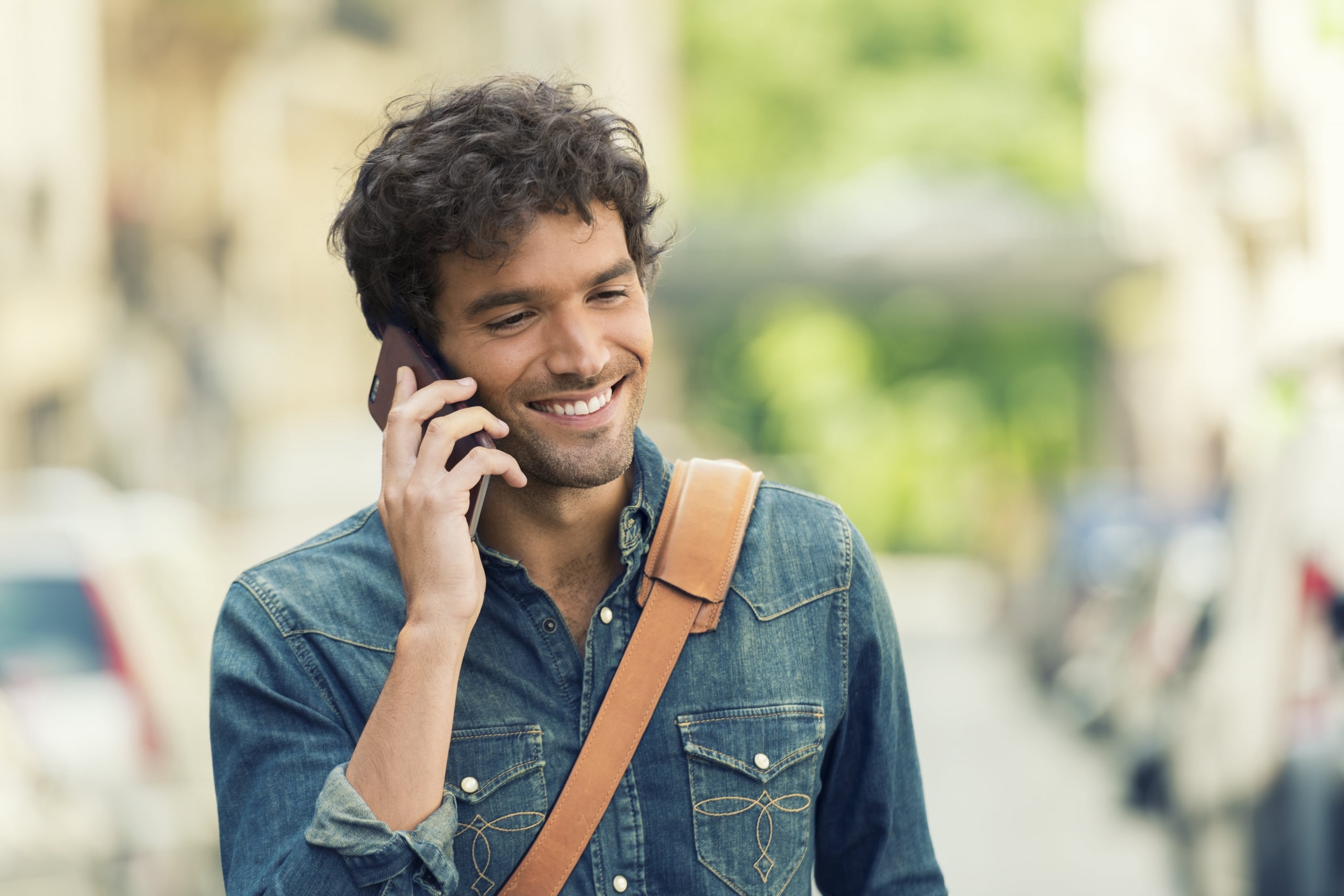 Cheerful male in the street on Mobile phone.