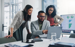 Contact center agents at a desk reviewing sentiment analysis reports.