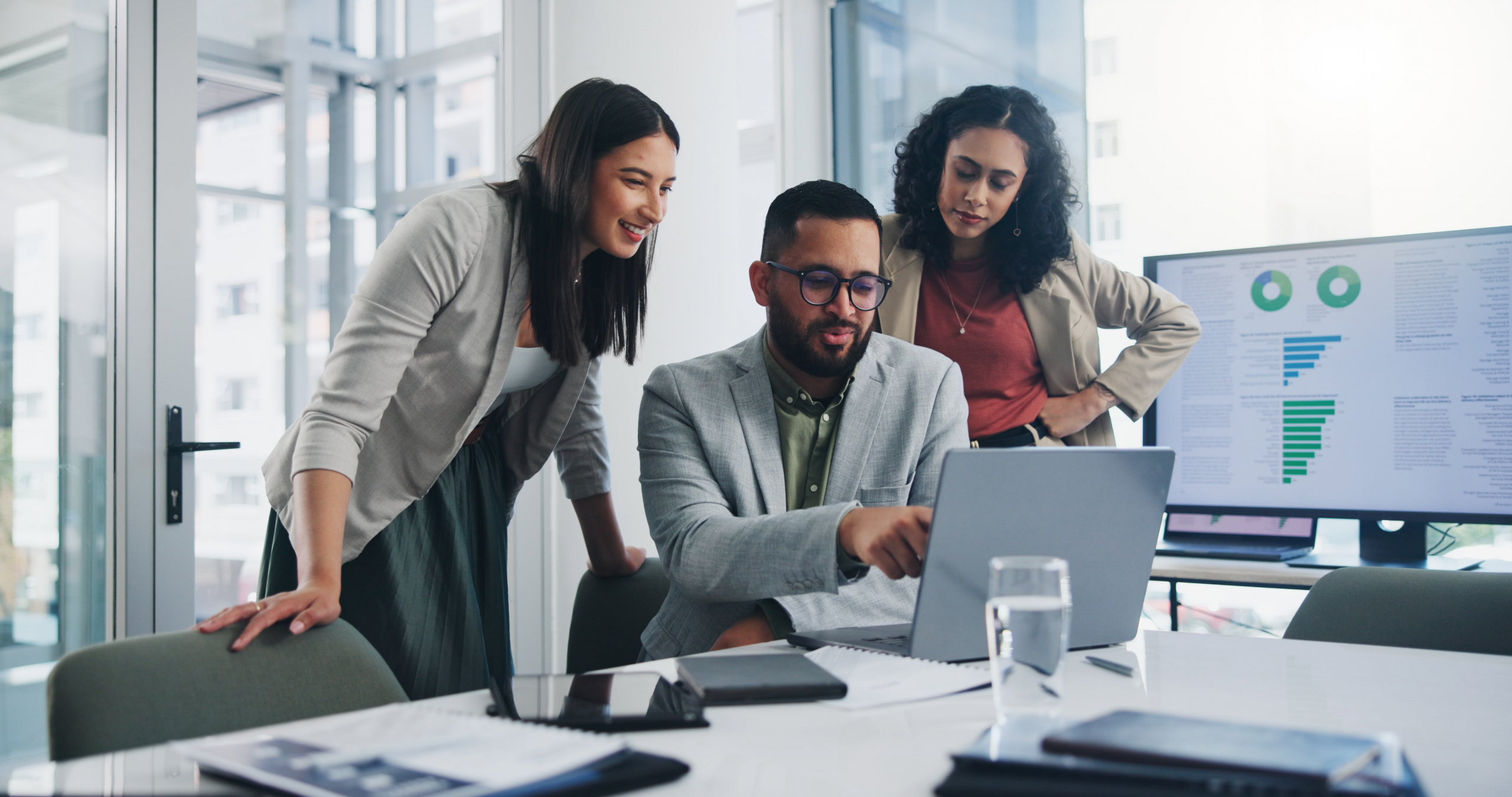 Contact center agents at a desk reviewing sentiment analysis reports.
