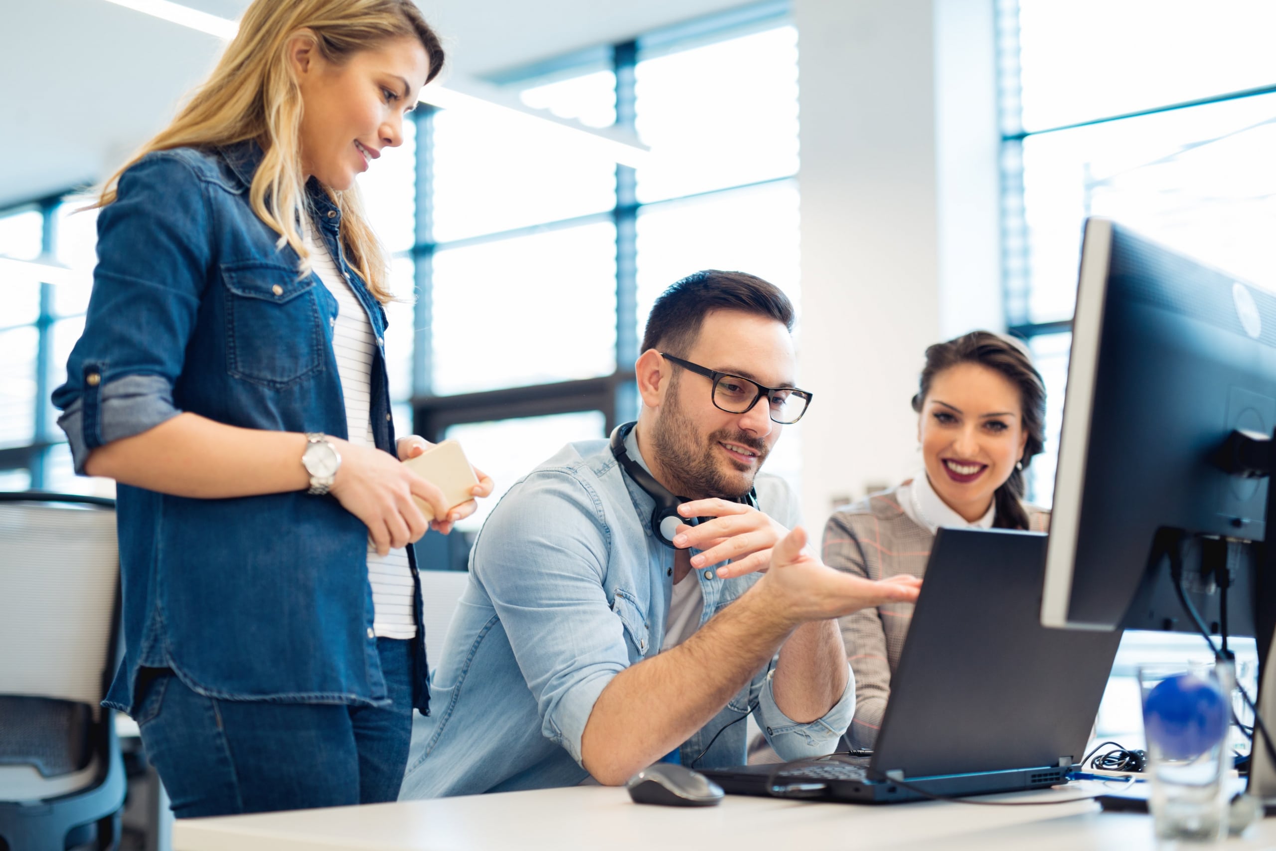 Group of co-workers looking at a computer screen