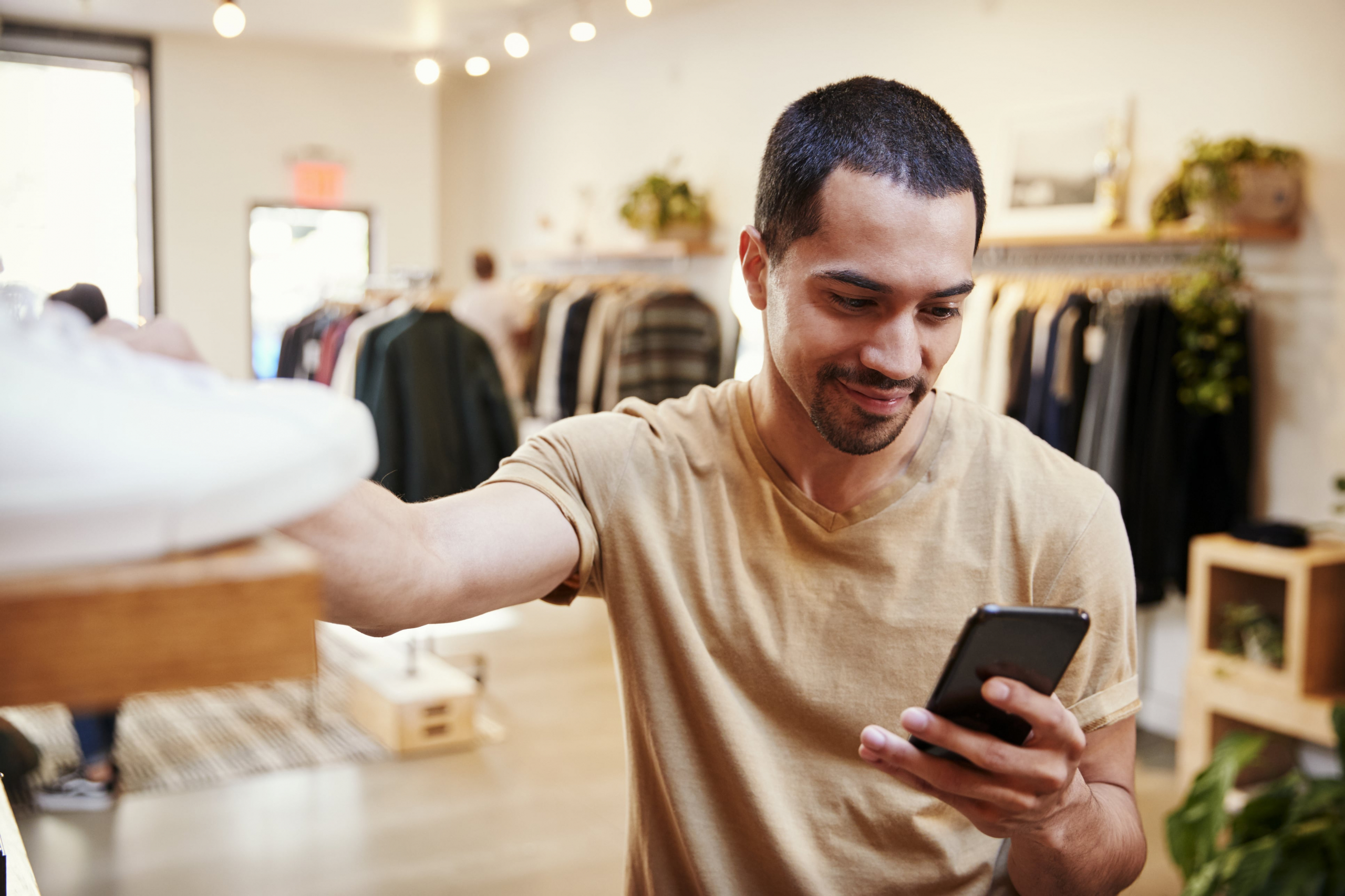 Young man shopping in a store looking at his phone