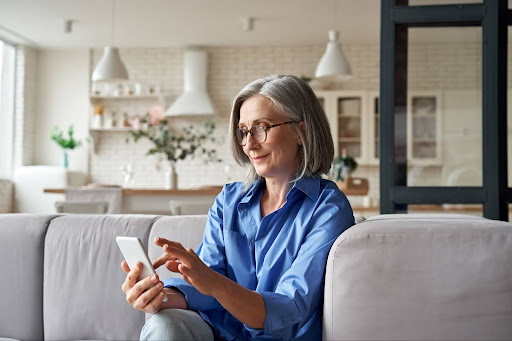 Older woman smiling and looking at her phone
