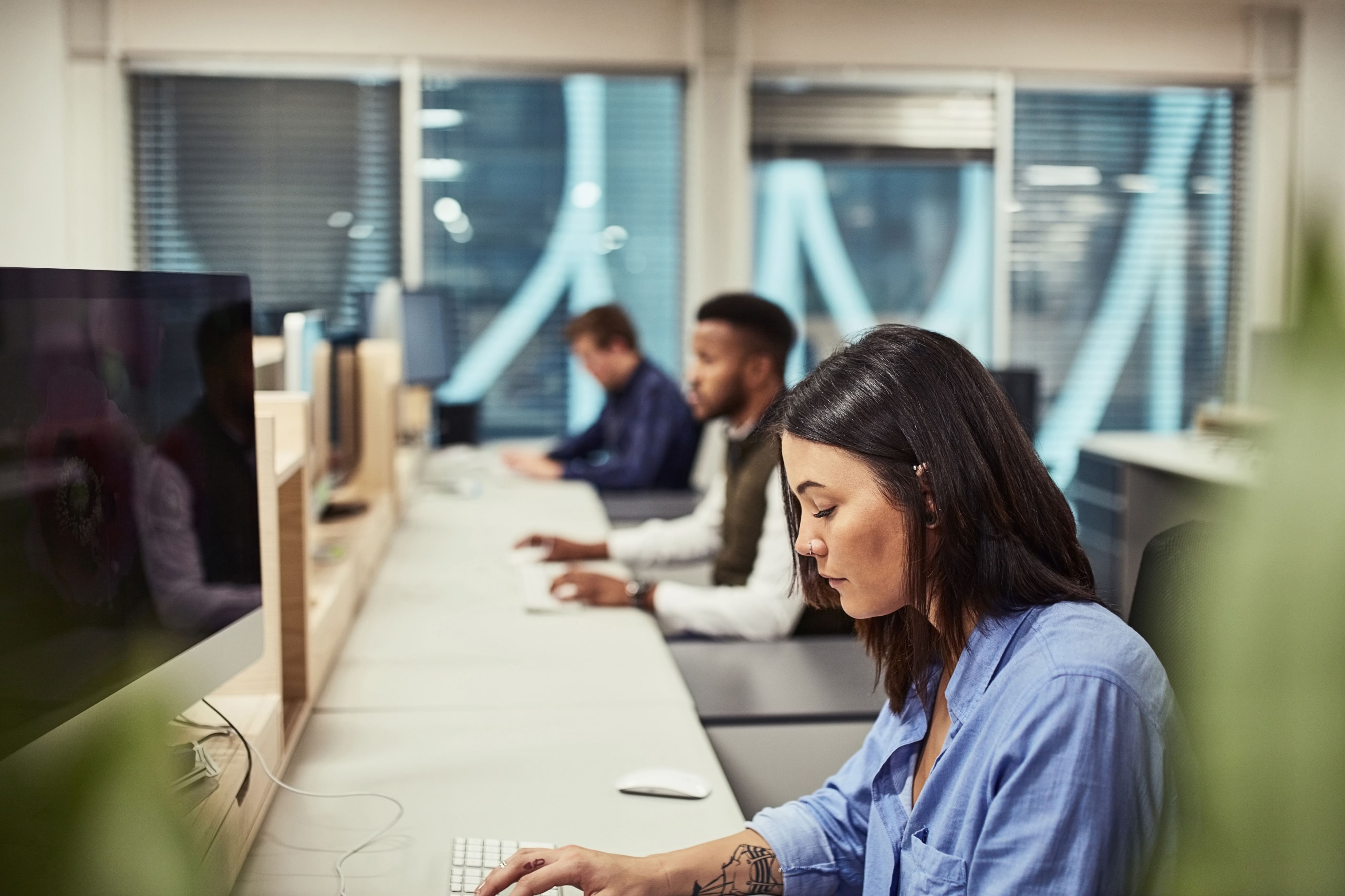 Cubicle, typing and businesswoman with computer in office with research for customer leads. Technology, coworking and group of insurance clerks with report for claims policy of clients at agency.