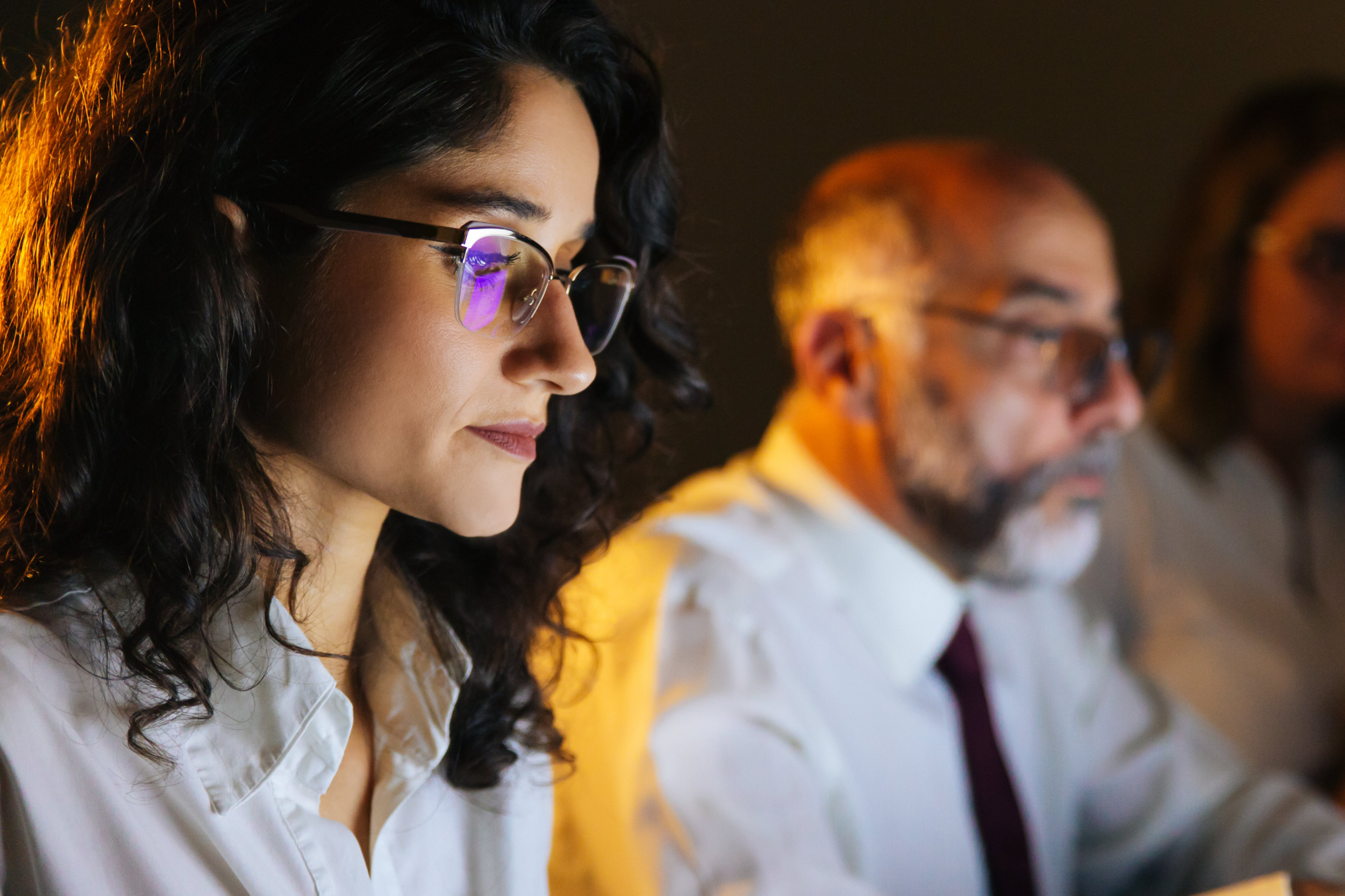 Female and male co workers looking at their computer screens