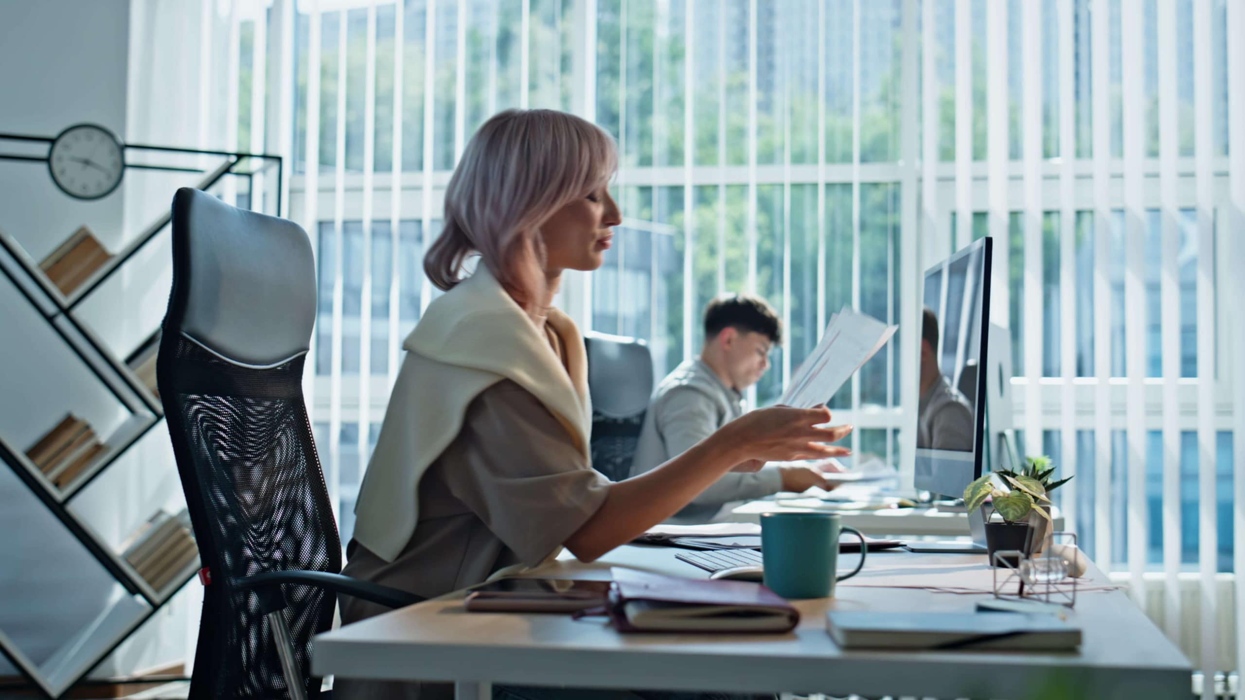 Woman looking at reports sitting at her desk in front of a computer