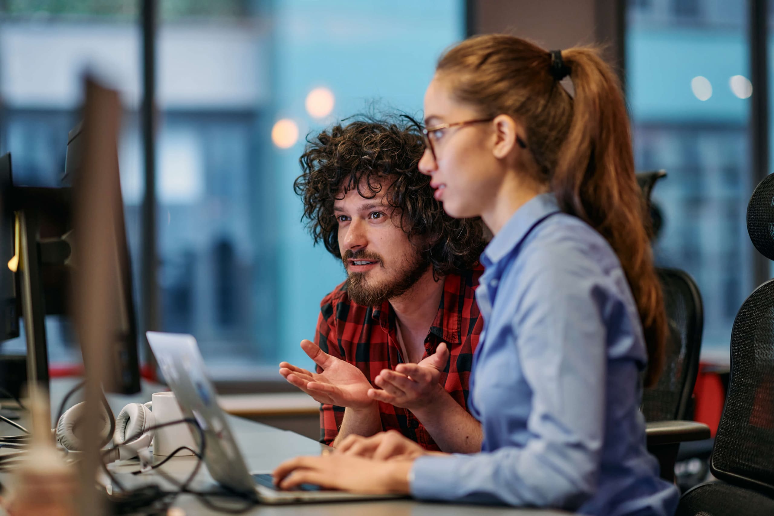 A female and male co-worker looking at a computer screen