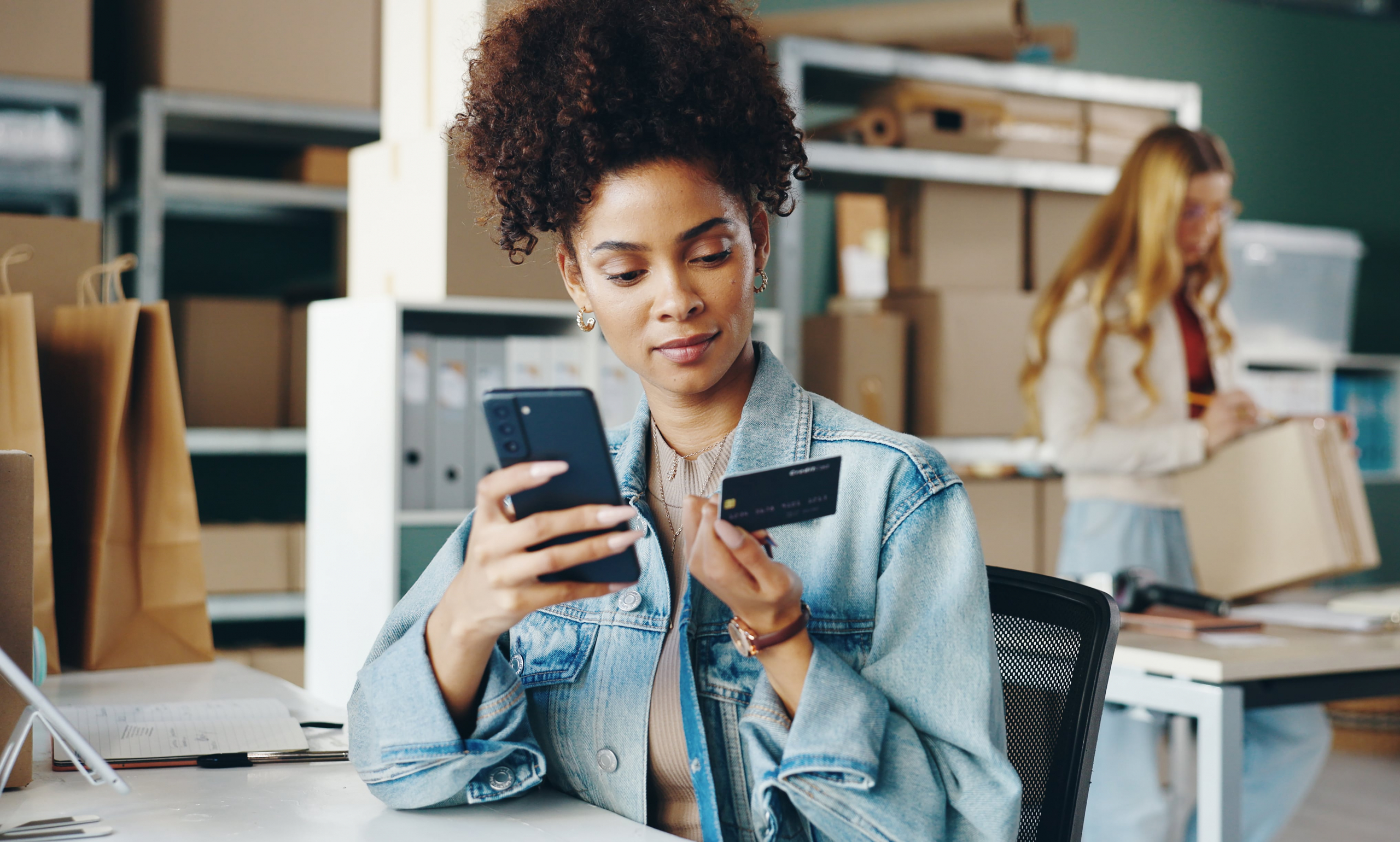 small business female owner using her credit card to pay for a service on her cell phone