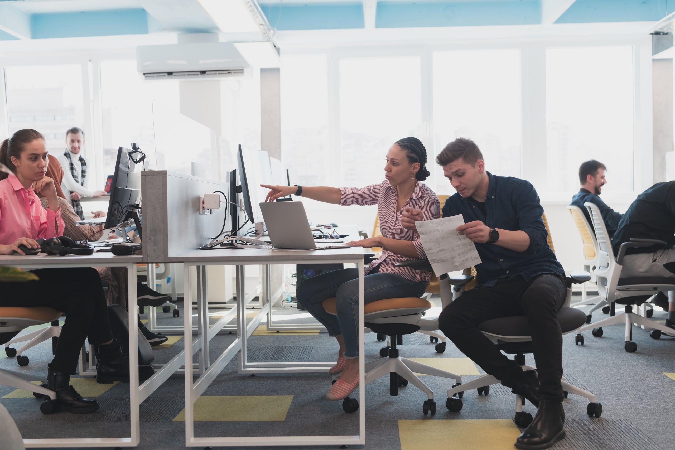Employees sitting at their desks working and looking at their computers