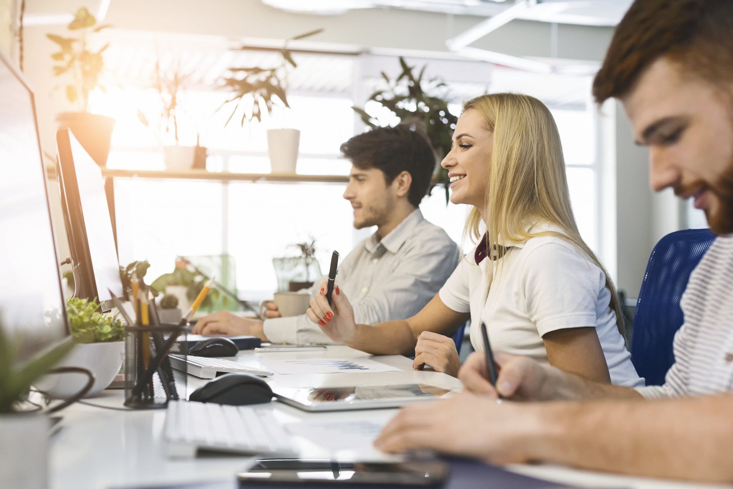 Customer acquisition and retention employees working at their desk at their computers