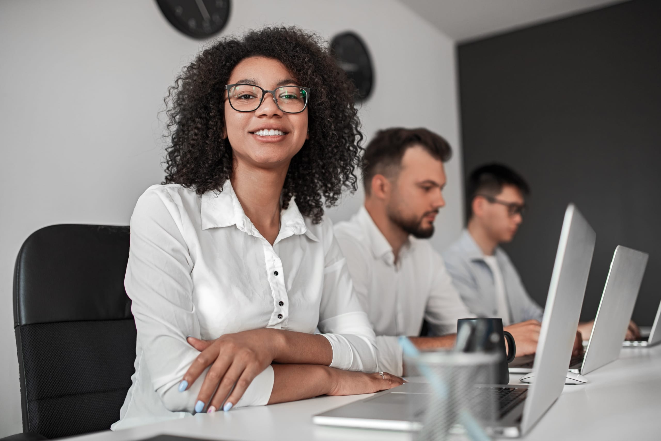Co-workers on their computers with an african american woman smiling