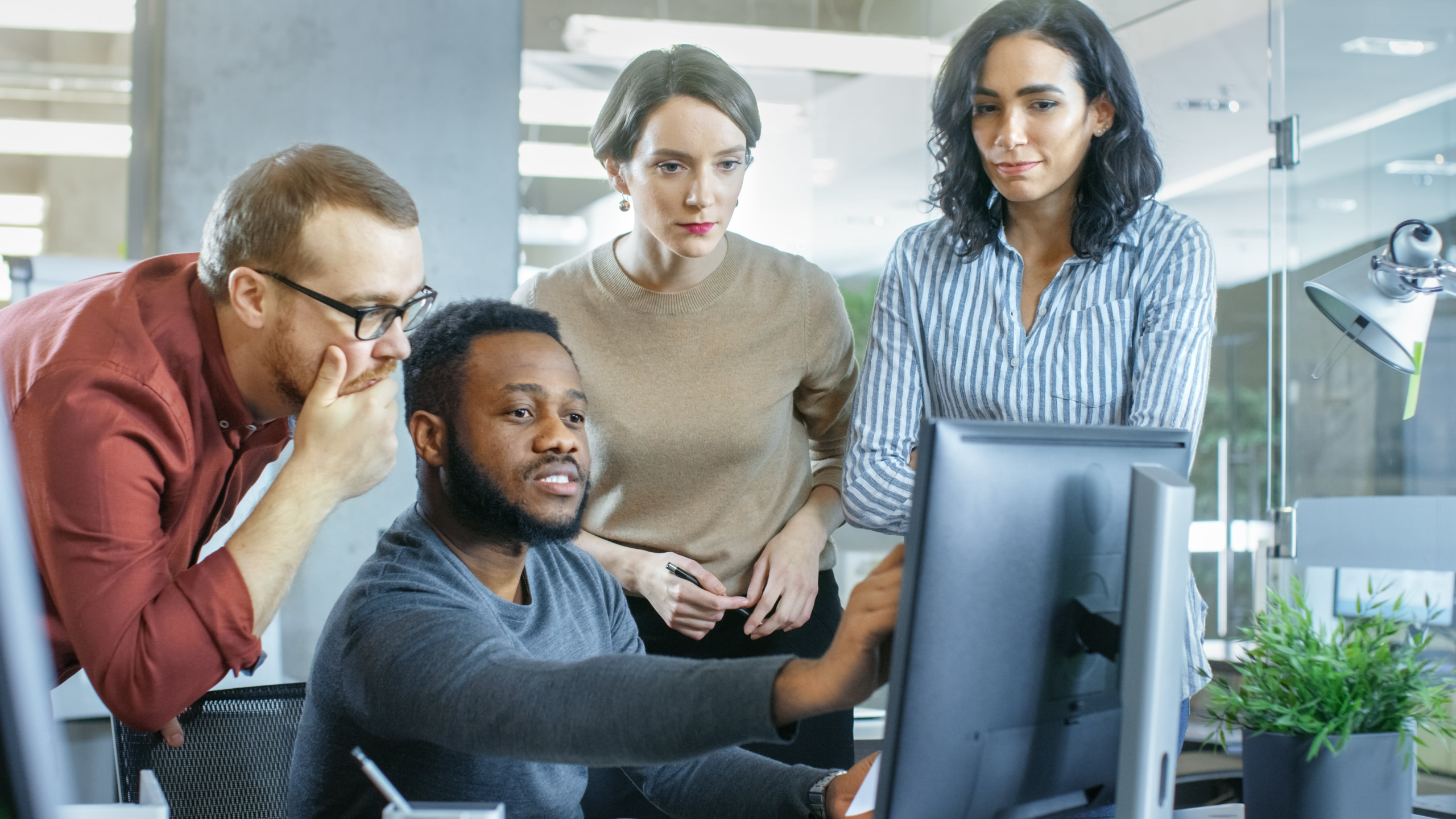 Group of co workers looking at 1 computer