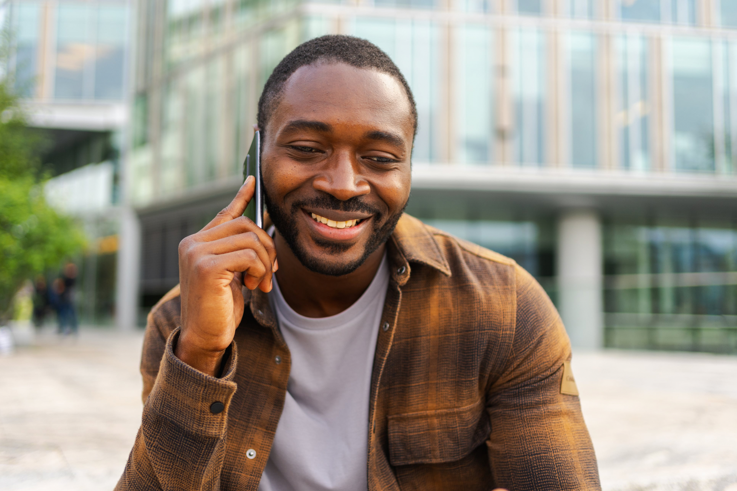 young african american male smiling talking on his cell phone