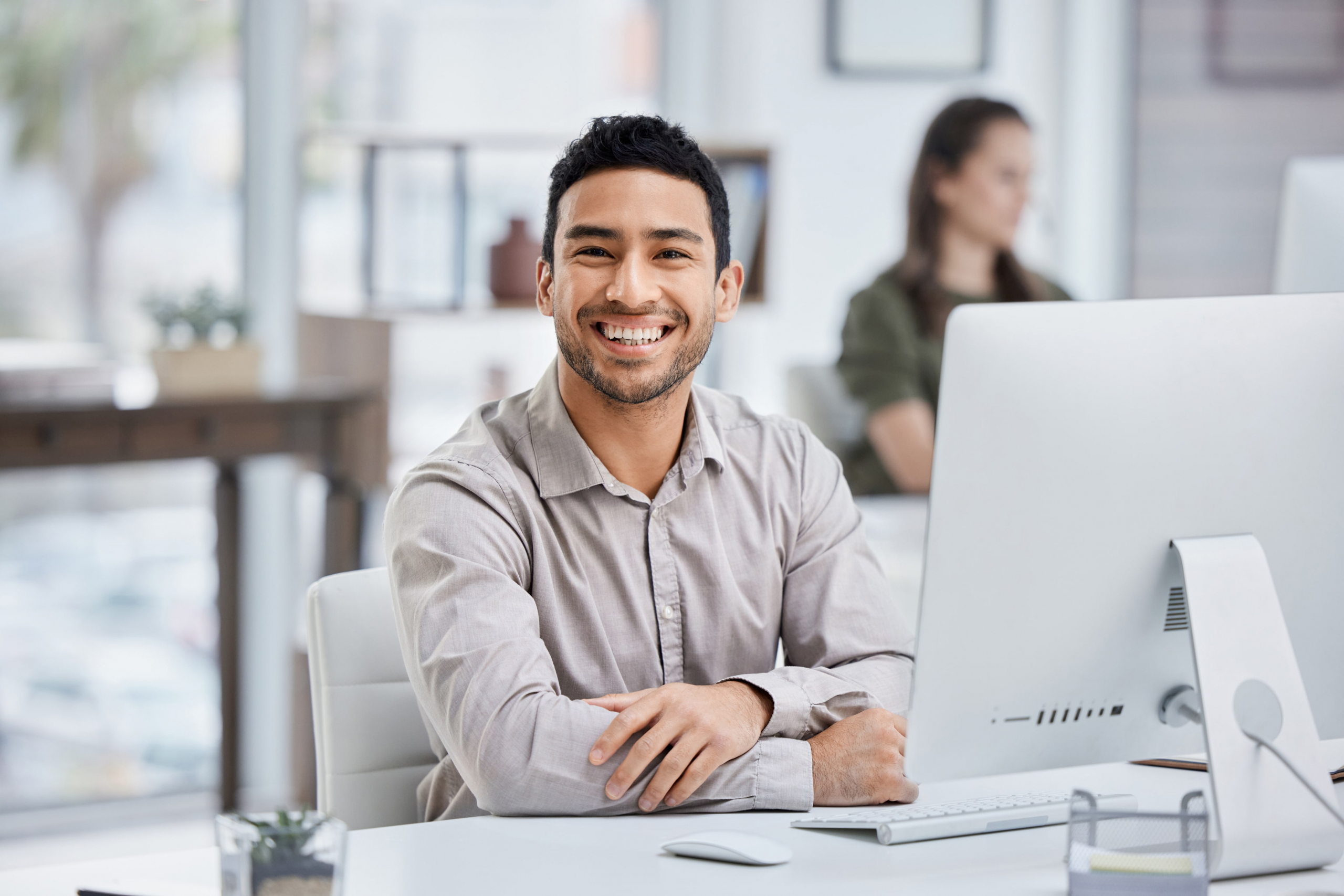 male office worker smiling at his computer