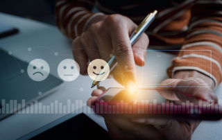 A customer experience management worker with a virtual image of smiley faces selecting their experience level.