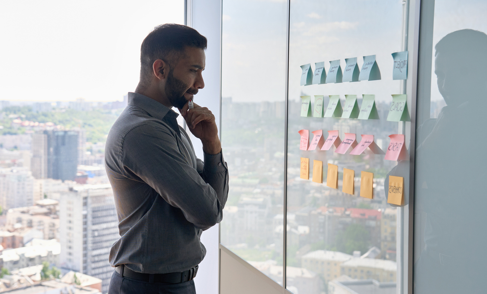 Serious,Thoughtful,Young,Indian,Businessman,Ceo,Near,Whiteboard,With,Adhesive