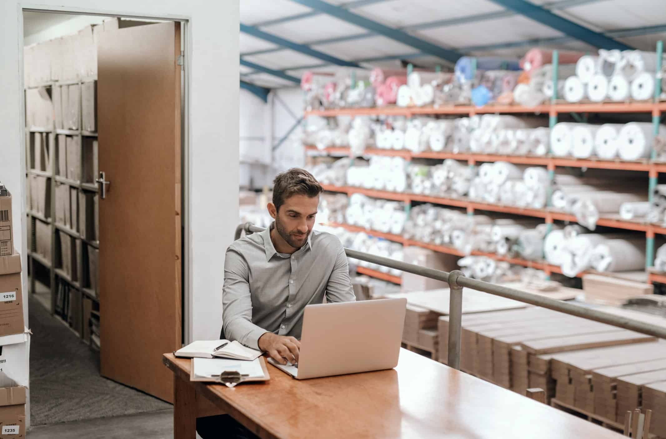 young man on his laptop responding to an email about support for his small business